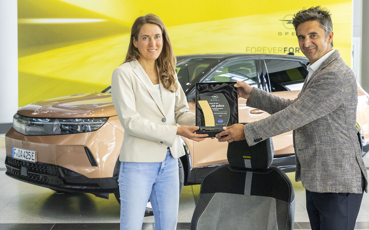 Kerstin Meier-Detjen, Mitglied des Direktoriums bei Aktion Gesunder Rücken e.V., übergibt die Auszeichnung für mehr als 20 Jahre besonders rückenschonendes Sitzen an Opel-Manager Jonas Eisenbraun.